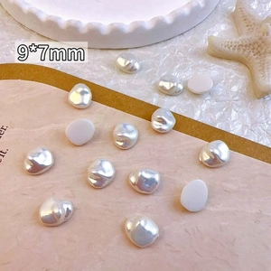 Close-up of 9x7mm baroque pearl nail charms on white tray with starfish prop