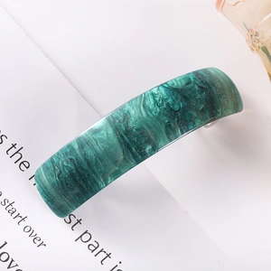 Detail shot of green marble acetate hair clip with golden glitter and curved design