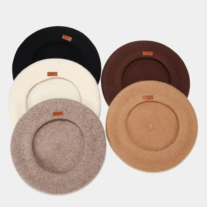 Detailed flat lay of wool beret hats in black, beige, coffee, camel and grey colors