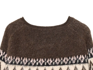 Detailed close-up of Nordic geometric jacquard pattern on brown wool knit sweater