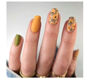 Close-up of matte short press-on nails in olive green, ginger yellow and floral patterns