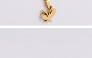 Macro shot of a polished golden butterfly pendant made of titanium steel with a smooth finish