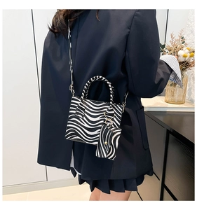 Detail view of zebra print handbag set with adjustable strap and mini coin purse charm