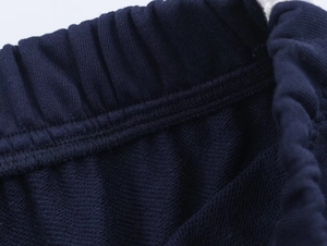 Détail du pantalon de jogging bleu marine montrant la taille élastique et la couture