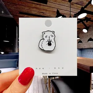 Detail of cute white cat pin drinking milk tea with enamel finish on display card
