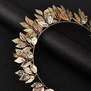 Detailed close-up of golden leaf headband with intricate metal leaf textures and finish