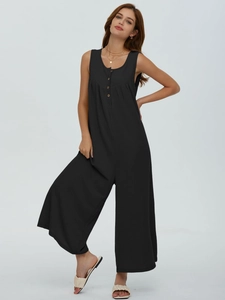 Detail view of black rib-knit sleeveless jumpsuit with wood-style buttons and crew neck