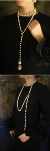 Dettaglio della collana lunga a Y con perle ed eleganti fiori dorati e piccoli uccelli