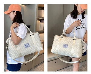 White quilted travel bag shown being worn as a crossbody and shoulder bag by a model