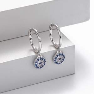 Macro shot of S925 sterling silver hoop earrings with blue zircon evil eye charms
