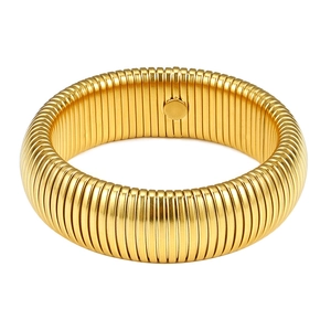 Macro detail of golden Tubogas style stretch bracelet with wide ribbed metal texture