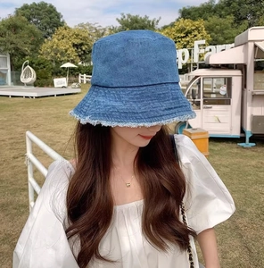 Détail du bob en jean bleu avec bords effilochés tendance dans un cadre extérieur ensoleillé