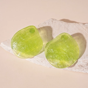 Macro detail of green translucent resin earrings with vertical stripe texture on stone