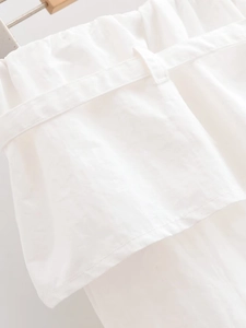 Vue détaillée de la texture du tissu blanc et des passants de ceinture à la taille