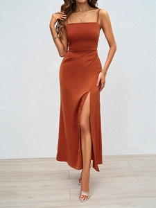 Détail de la robe en satin caramel montrant la fente haute et le drapé élégant du tissu