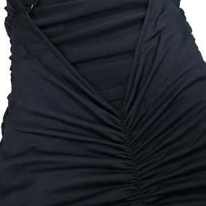 Close-up of black bodycon dress featuring elegant back ruching and V-shaped seam detail