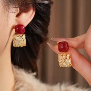 Macro shot of square red zircon earrings with gold plating and clear crystal details