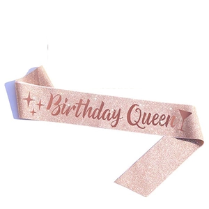 Close-up of rose gold glitter sash featuring Birthday Queen text and star details