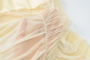 Detail of sheer mesh panel texture and breathable fabric on backless mini dress