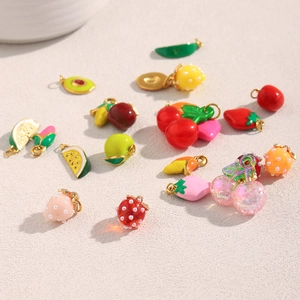Close-up of diverse 18K gold plated strawberry and cherry fruit charms for DIY jewelry making