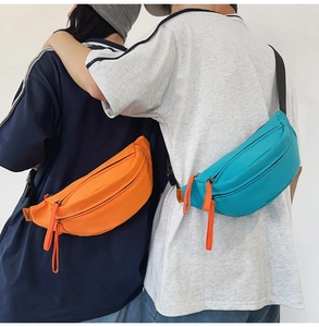Detailed back view of orange and blue waterproof nylon crossbody bags on models
