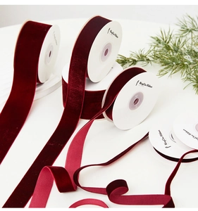 Detailed view of various widths of dark red velvet ribbons for festive gift wrapping