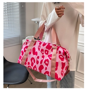 Close-up of pink leopard print travel bag with reinforced handles and metallic hardware