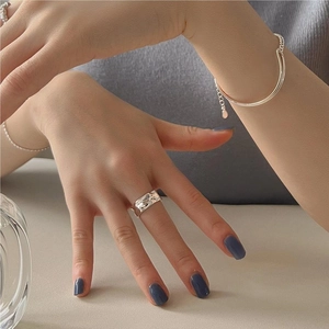 Close-up of S925 sterling silver irregular texture ring and minimalist bangle on hand