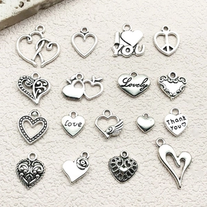 Macro view of assorted alloy heart charms with Love engraving and hollow patterns