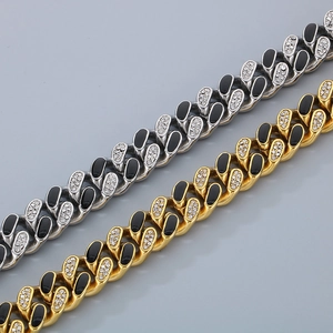 Detail of gold and silver cuban chains with black oval inserts and paved crystal rhinestones