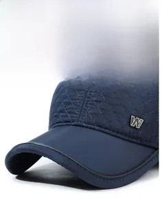 Détail de la texture matelassée et du logo en métal sur la casquette d'hiver pour homme