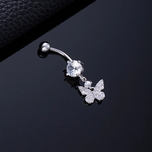 Macro detail of silver butterfly belly ring with sparkling zircon tassels on black surface