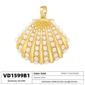 Detail view of a gold shell pendant made of brass with elegant pearl inlay craftsmanship