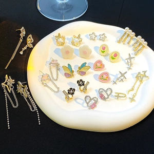 Sammlung französischer Luxus-Blumenohrringe mit Zirkon und Perlen auf weißem Porzellan