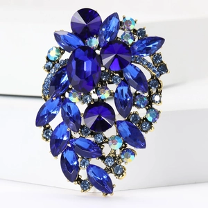 Macro shot of blue faceted crystals and AB rhinestones set in golden alloy brooch