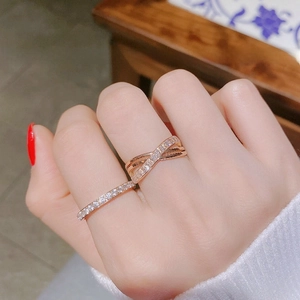 Detailed close-up of a rose gold criss-cross ring set with fine cubic zirconia stones