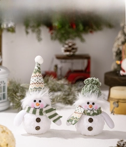 Detail of Christmas snowman plushies wearing green knit hats with festive lighting decor