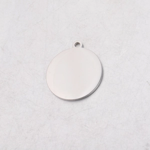 Close-up of a polished round stainless steel blank charm pendant with top hanging hole