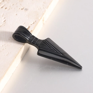 Macro shot of 20mm black stainless steel arrow pendant with engraved geometric lines