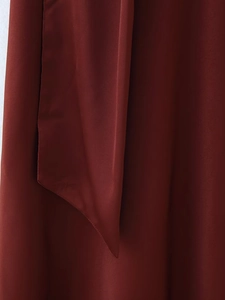 Detail of burgundy midi dress showing high-quality silky fabric texture and draped cut
