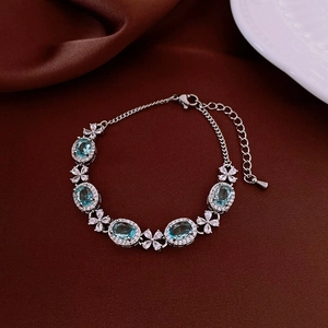 Exquisite silver-tone bracelet featuring oval sky blue zircon and floral diamond accents