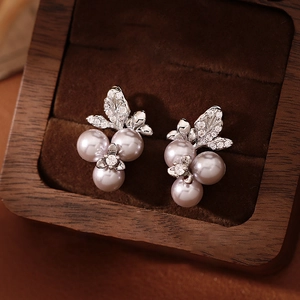 Detail of vine leaf pearl earrings with purple pearls and zircons in a jewelry box