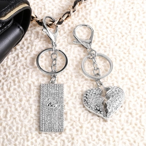 Silver crystal rhinestone money and heart keychain charms on soft knit fabric