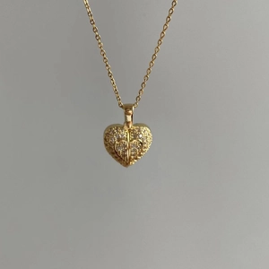 Exaggerated golden heart pendant necklace with shimmering crystals on a sleek link chain