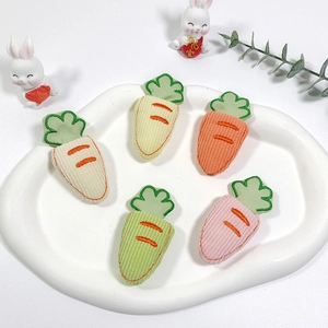 Five cute corduroy carrot hair clips on a white plate with bunny dolls for girls