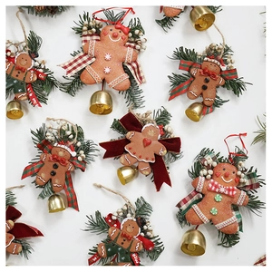 Detail view of gingerbread man ornaments with artificial pine needles and festive bells