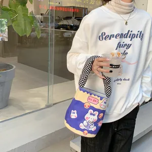 Detail der Kontrast-Beuteltasche mit Hasen-Print und kariertem Griff für Damenmode
