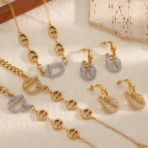 Luxury gold and silver stainless steel jewelry set with pavé zircon stones on stone background
