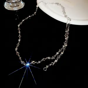Long silver heart tassel necklace with sparkling rhinestones and layered chain links
