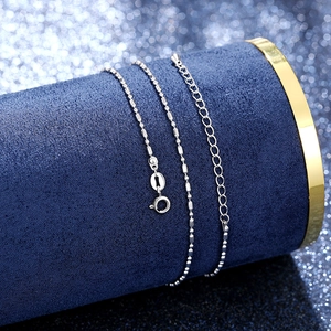 Close-up of silver bead and cylinder chain with spring clasp on blue velvet
